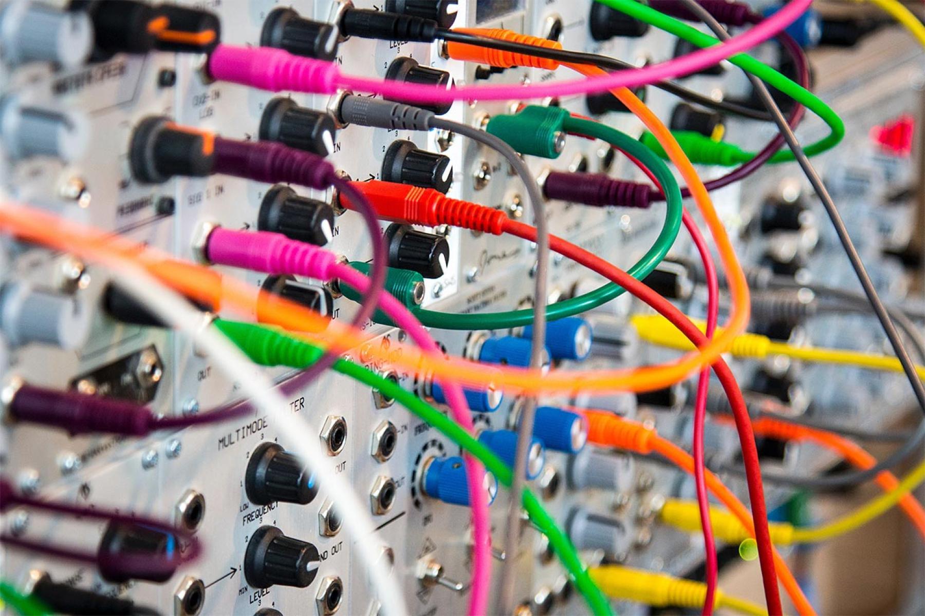 Colourful patch cables plugged into complex device
