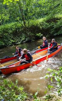 Young people kayaking down river