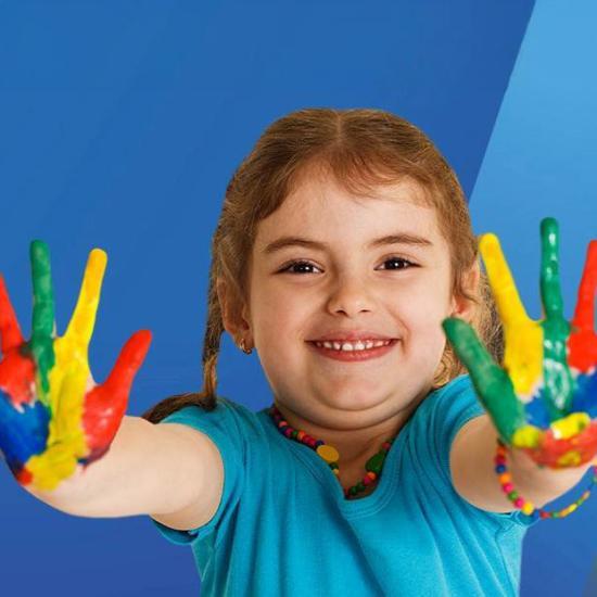 Smiling child with bright paint on their hands