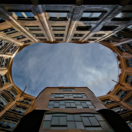 a skyward view rimmed with rising buildings encircling the image