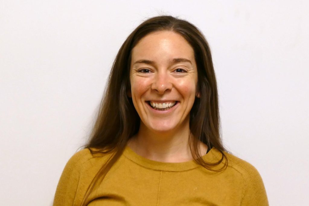 Grace Robertson smiling in a mustard jumper