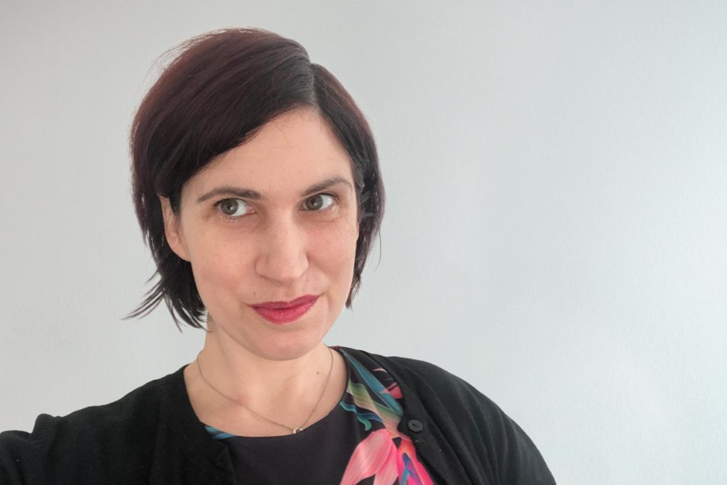 Jeanette Sutton with short dark hair, in a black cardigan